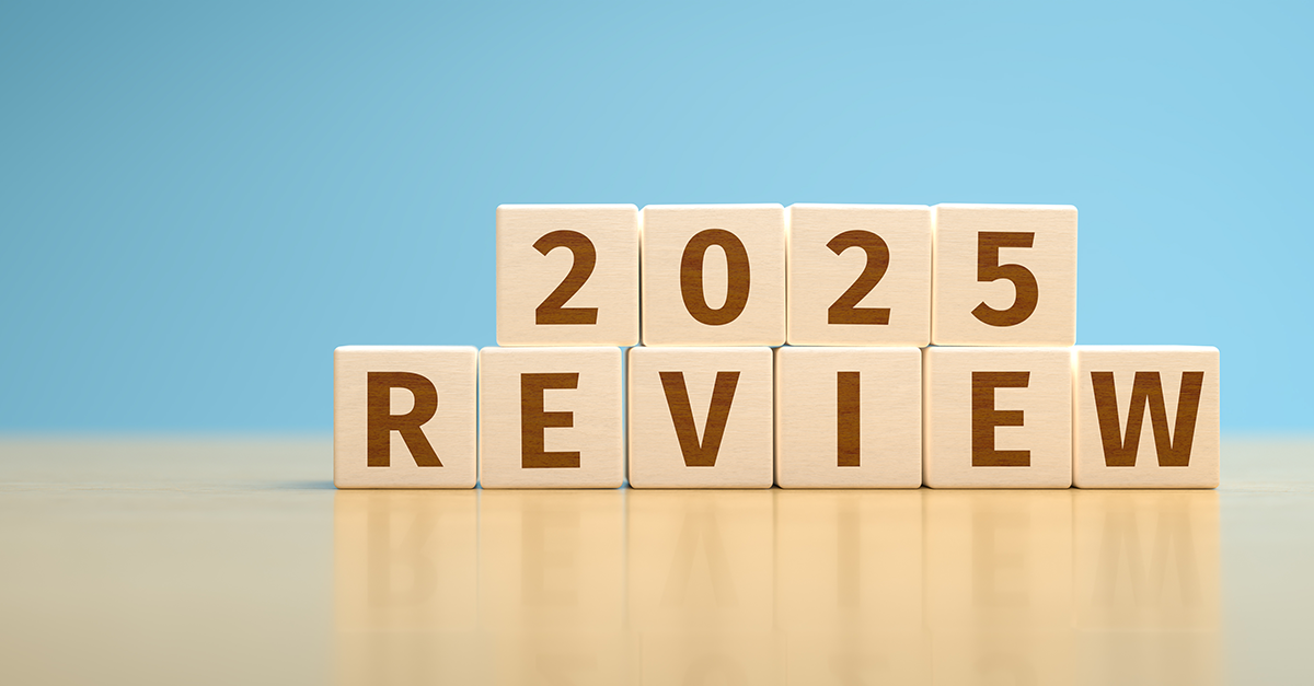 A blue background with a wooden table in the foreground. There are wooden blocks on the table which read 2025 Review.